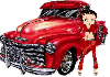 Betty Boop in red standing beside old red pickup